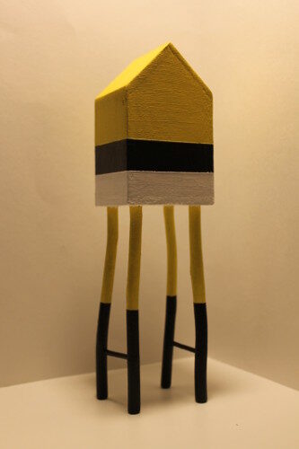 Haut de 1 mètre, cette maison miniature en bois est peinte en jaune, gris et noir