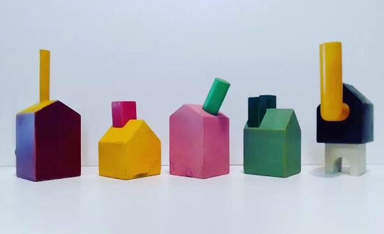 Cinq objets en forme de maison en bois peints en couleurs vives